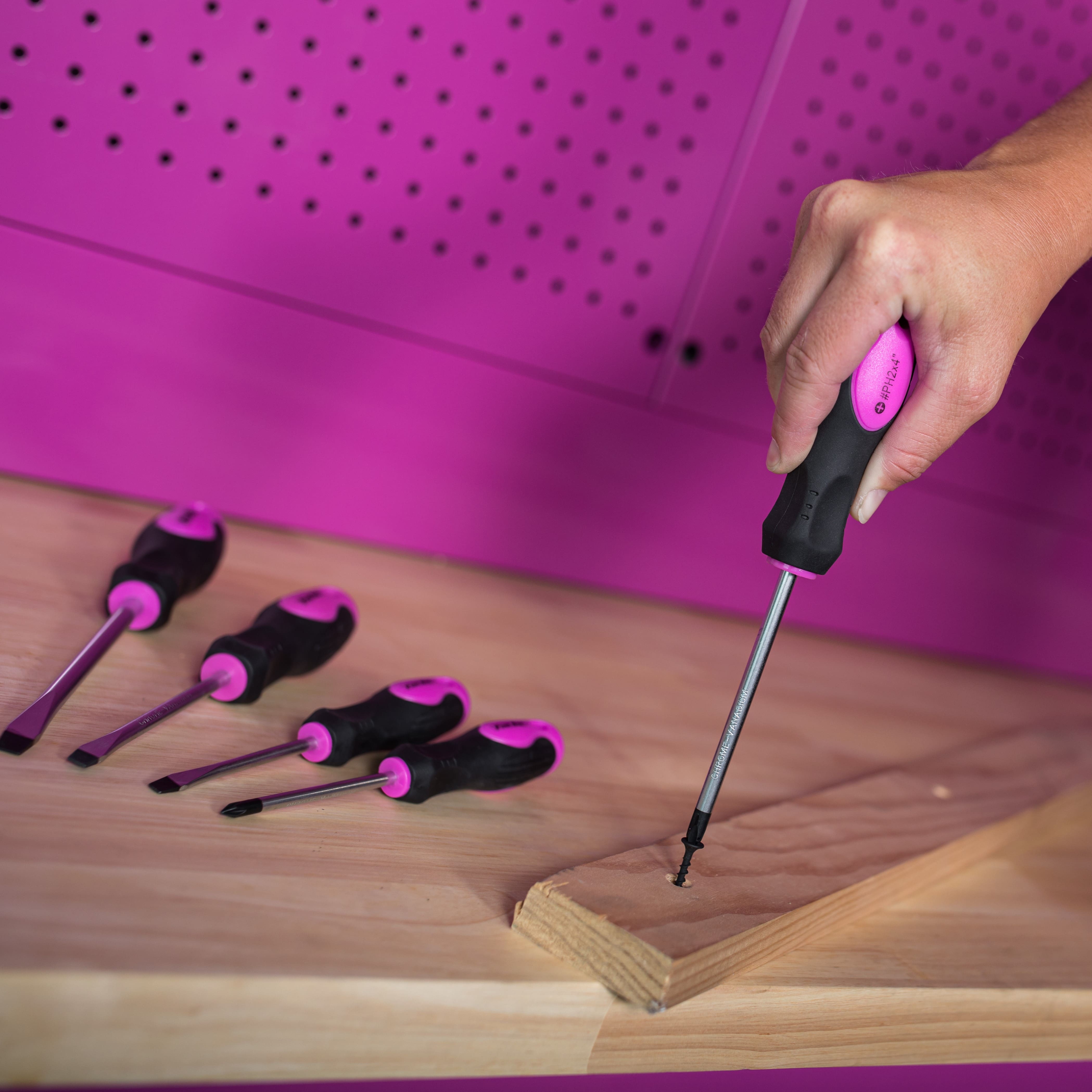 pink screwdriver being used on wood