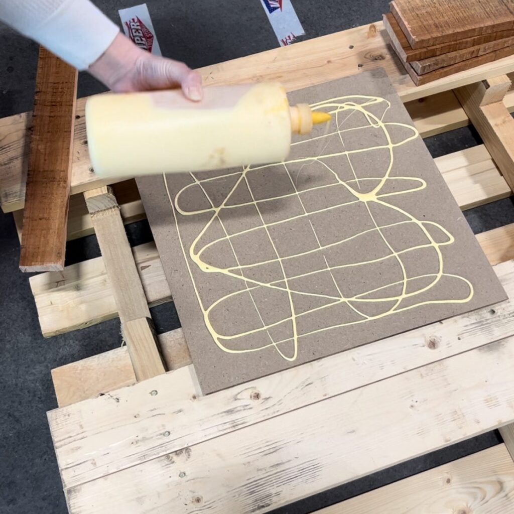 adding glue to a piece of particle board